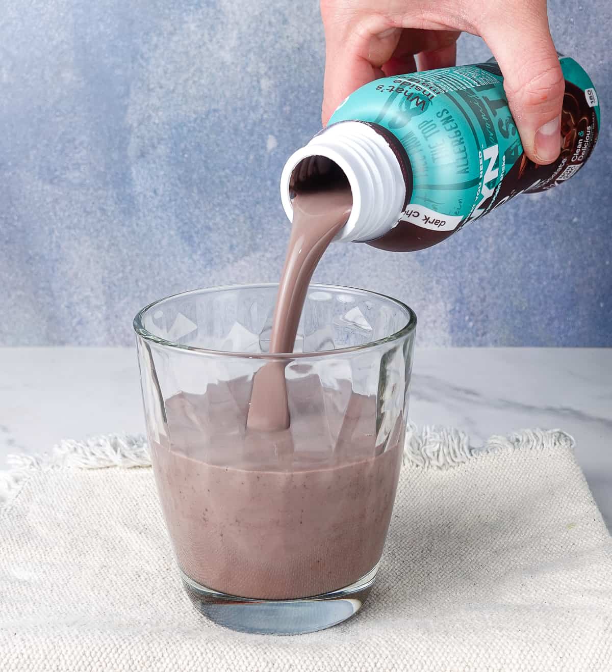 Pouring OWYN chocolate shake